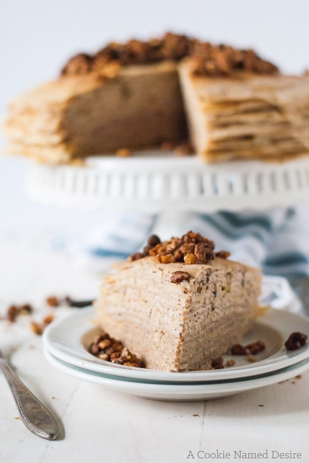 This crepe cake is filled with candied nuts and drizzled with a traditional baklava orange honey sauce