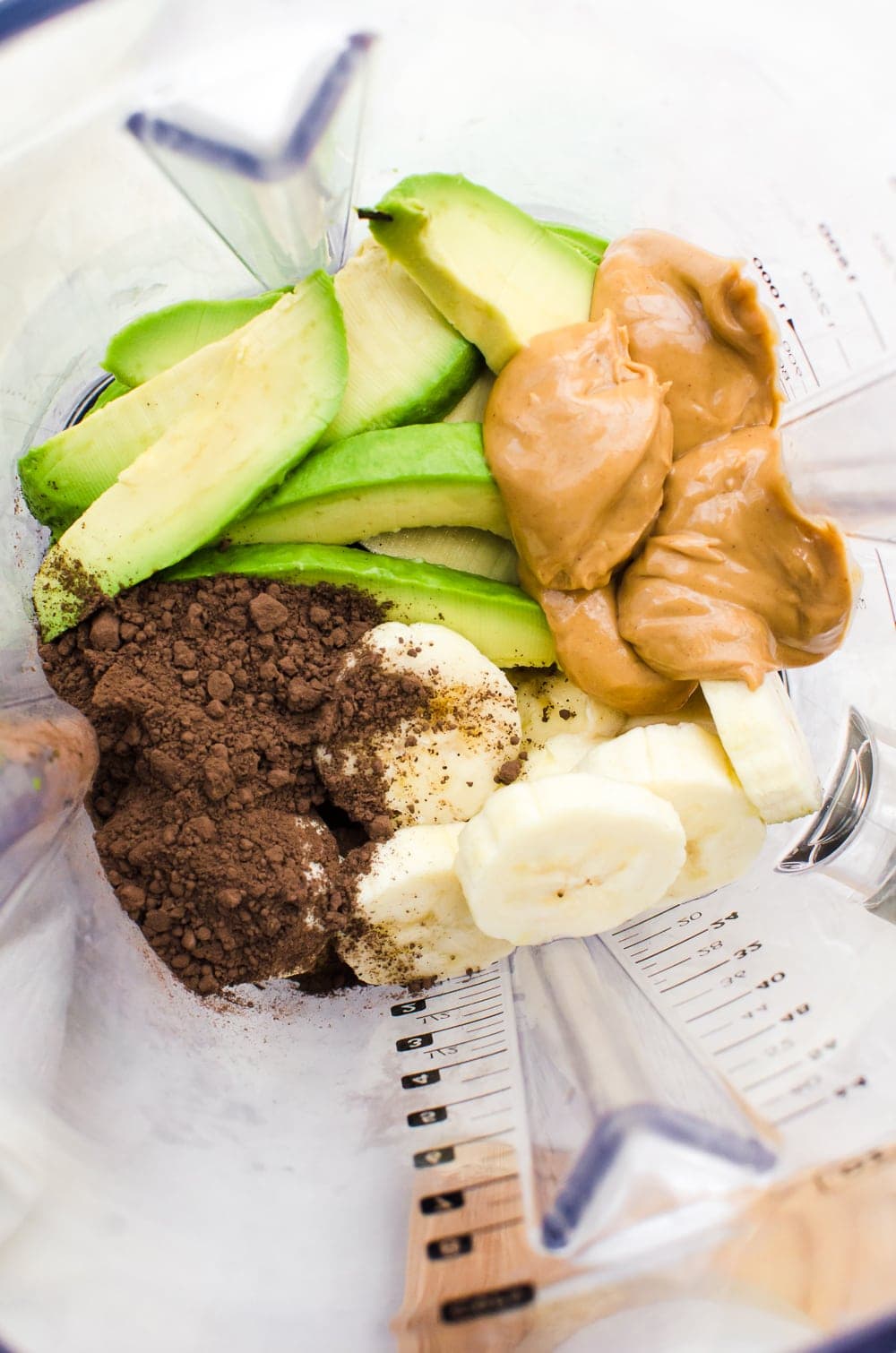 avocado chocolate peanut butter smoothie ingredients in a blender close up