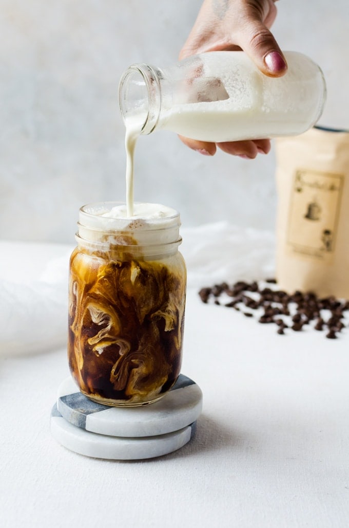 cold brew coffee being topped with cream