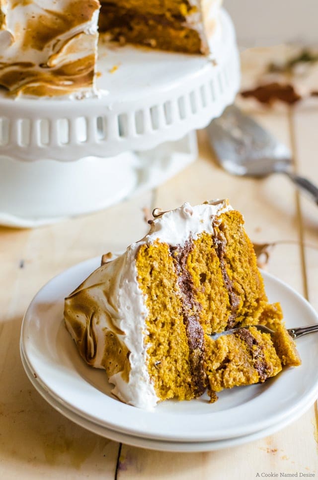 Enjoy a slice of this moist pumpkin cake with ginger chocolate frosting and toasted cinnamon meringue