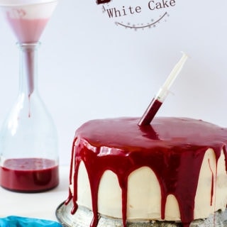 This bloody white cake is the perfect addition to your Halloween party. This white cake with raspberry jam and red velvet ganache is as delicious as it is gory!