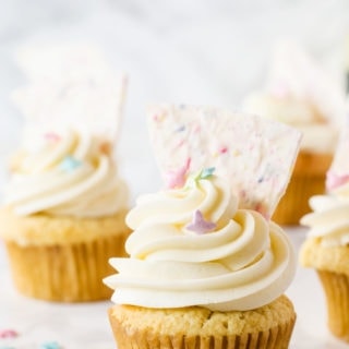 Celebrate Spring with these heavenly vanilla cupcakes filled with a bright lemon curd and topped with a fun sprinkle-filled white chocolate bark!