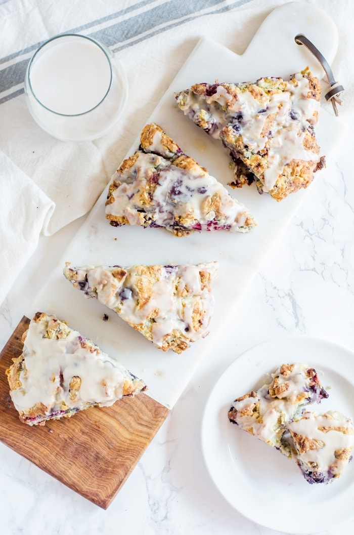 Tender mixed berry scones filled with blueberries, blackberries, raspberries, and strawberries then topped with a sweet vanilla glaze. Berry scones like these make excellent treats for breakfast, brunch, or with tea. 