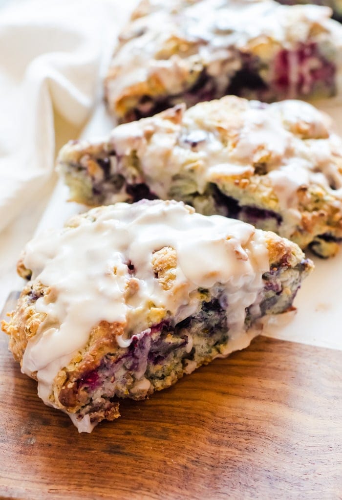 Tender mixed berry scones filled with blueberries, blackberries, raspberries, and strawberries then topped with a sweet vanilla glaze. Berry scones like these make excellent treats for breakfast, brunch, or with tea. 