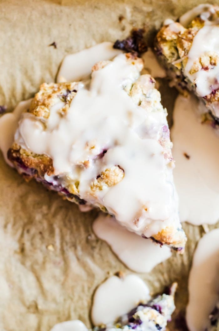 Tender mixed berry scones filled with blueberries, blackberries, raspberries, and strawberries then topped with a sweet vanilla glaze. Berry scones like these make excellent treats for breakfast, brunch, or with tea. 