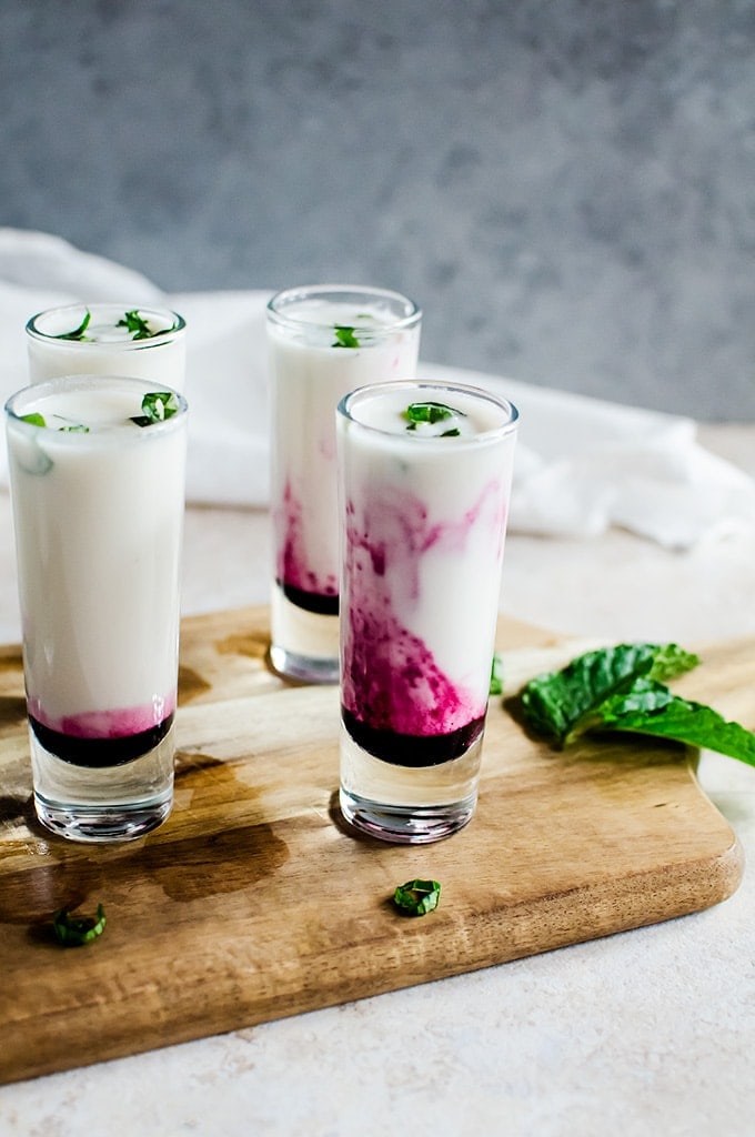 Fall in love with these creamy coconut lime mojito shooters with blueberry swirl. It will be your new favorite summer drink