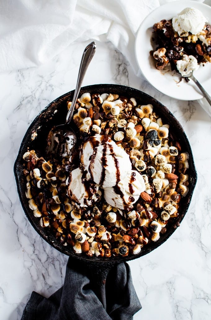 Overhead photo of brownies in pan topped with toasted marshmallows and nuts