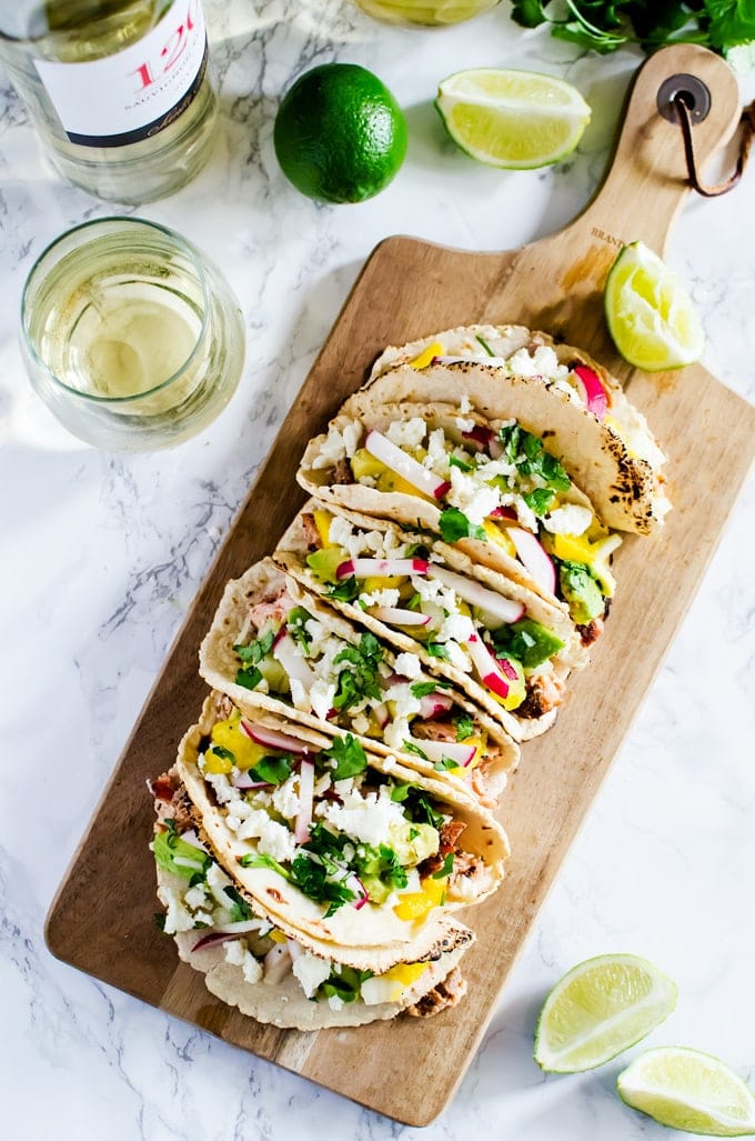 Cedar grilled salmon tacos with a refreshing avocado mango salsa and homemade corn tortillas. The best thing you will make this summer. 