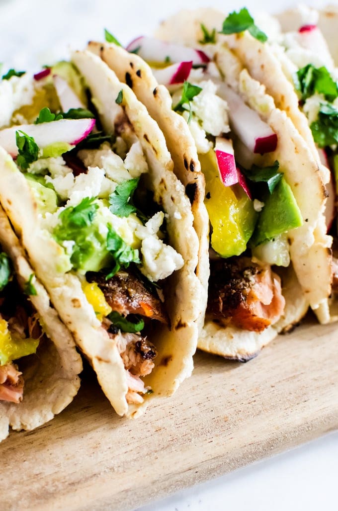 Flaky grilled salmon tacos with a refreshing mango avocado salsa. The perfect summer BBQ recipe