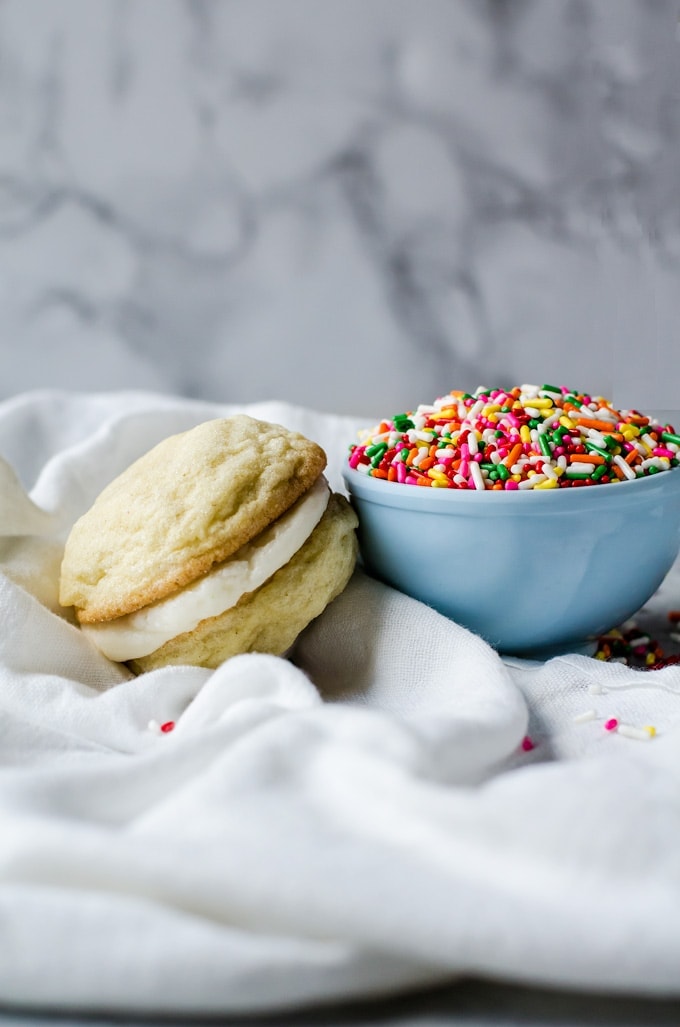 Enjoy life with these lemon sandwich cookies with cake batter frosting. These are tasty and fun sandwich cookies everyone will love