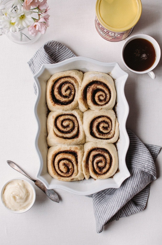 baked coffee colls in pan next to icing