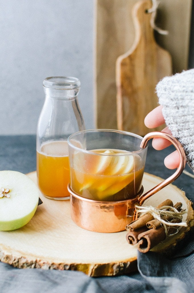 hand grabbing toddy garnished with apples