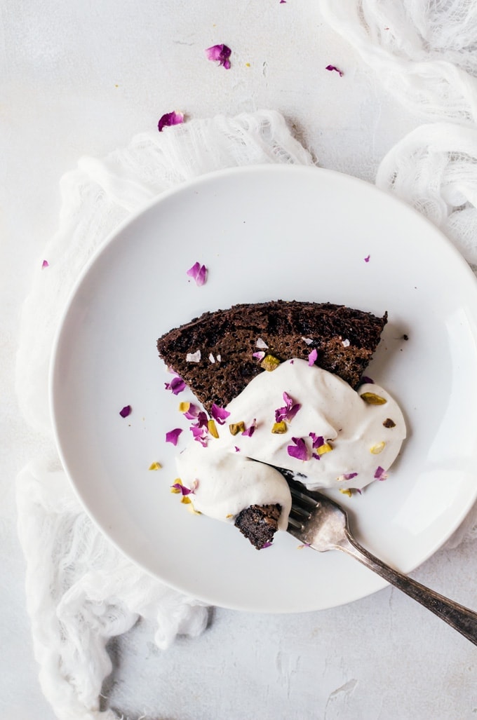 A simple sweet chocolate olive oil cake with pistachios, rose, and a light cardamom whipped cream