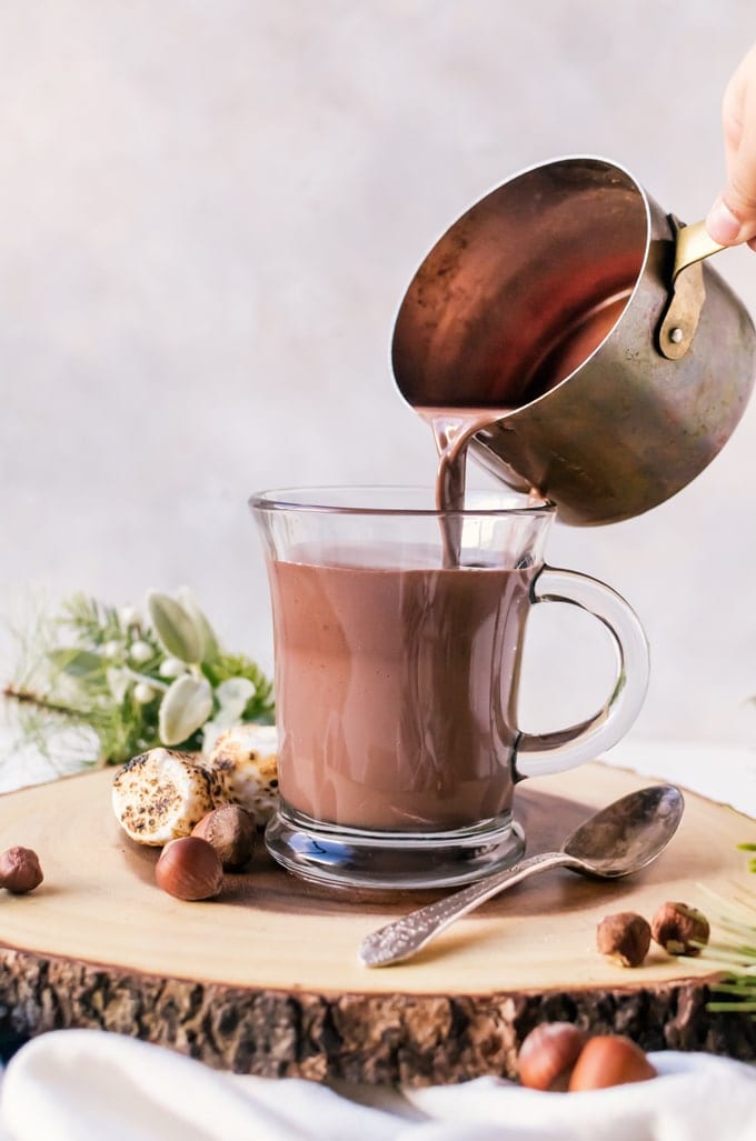 saucepan pouring hot chocolate into mug