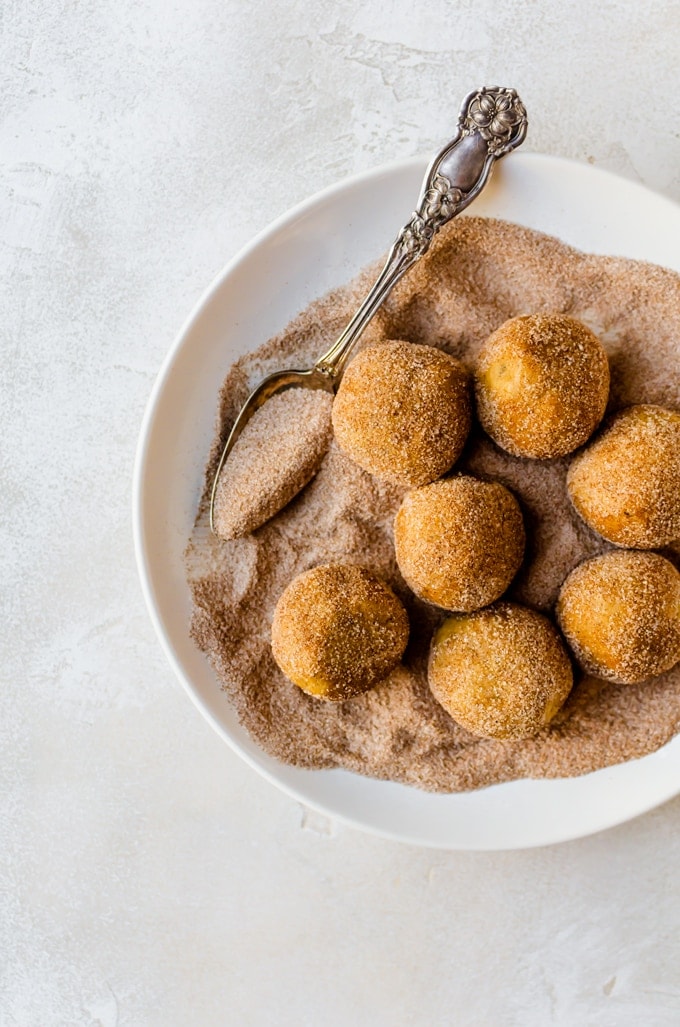 cookie dough being rolled in cinnamon sugar