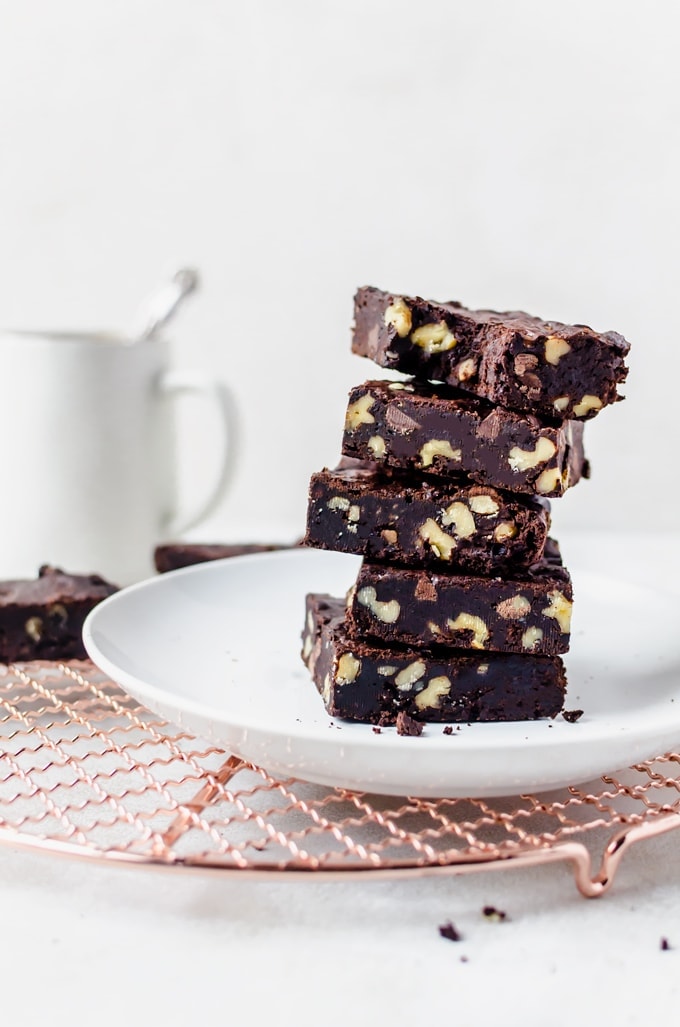 stacked coffee brownies with walnuts on a white plate on wire rack