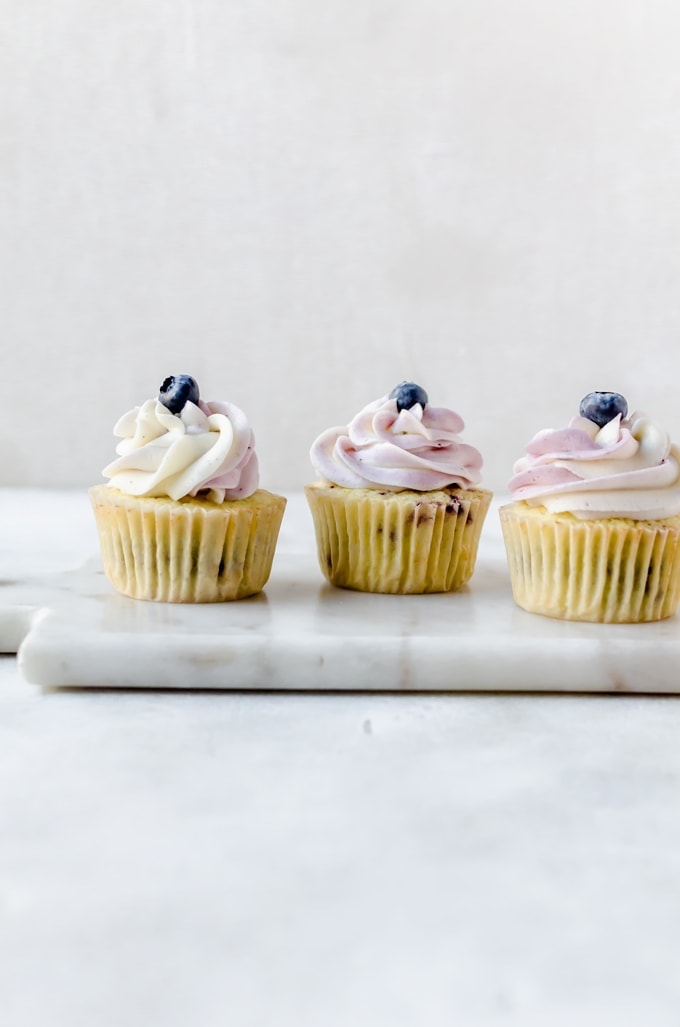 three cupcakes in a row on marble tray