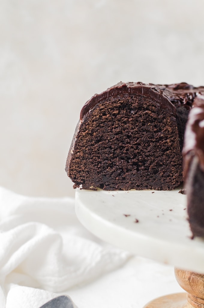 chocolate stout bundt cake on a cake stand with slice cut out