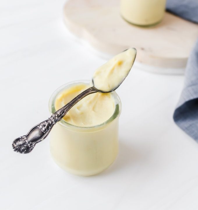 a jar of creme patissiere with a spoon resting on top