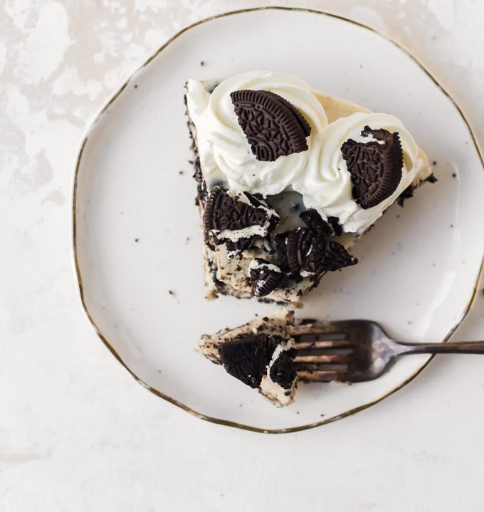 An ocerhead photo of a slice of No-bake Oreo Cheesecake on a plate with a forkful of cheesecake