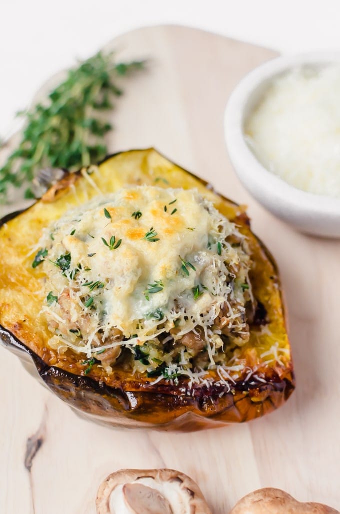 close up of turkey stuffed acorn squash on chopping board