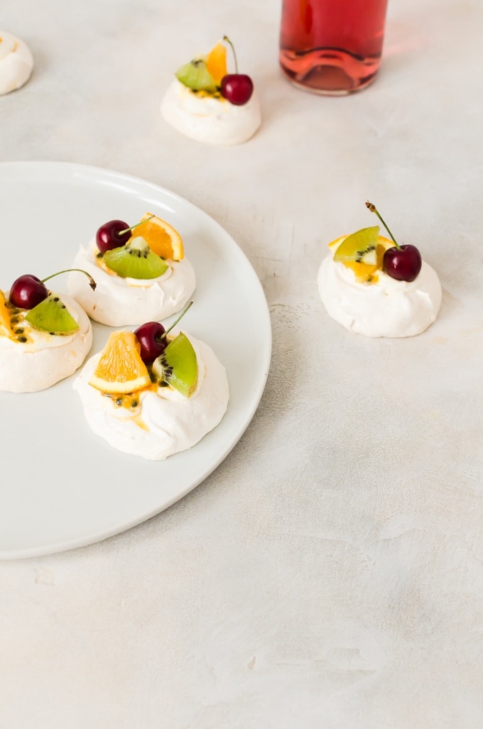 summer fruit on top of whipped cream and mini pavlova