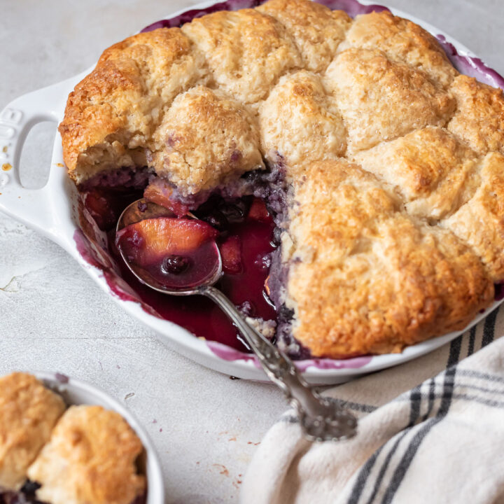 blueberry peach cobbler in pan being served