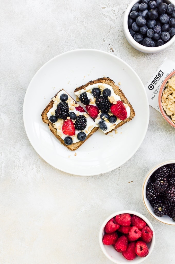 breakfast toast on a white plate with fruit in bowls