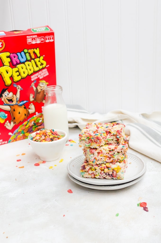 fruity pebble rice crispy treats stacked on a plate