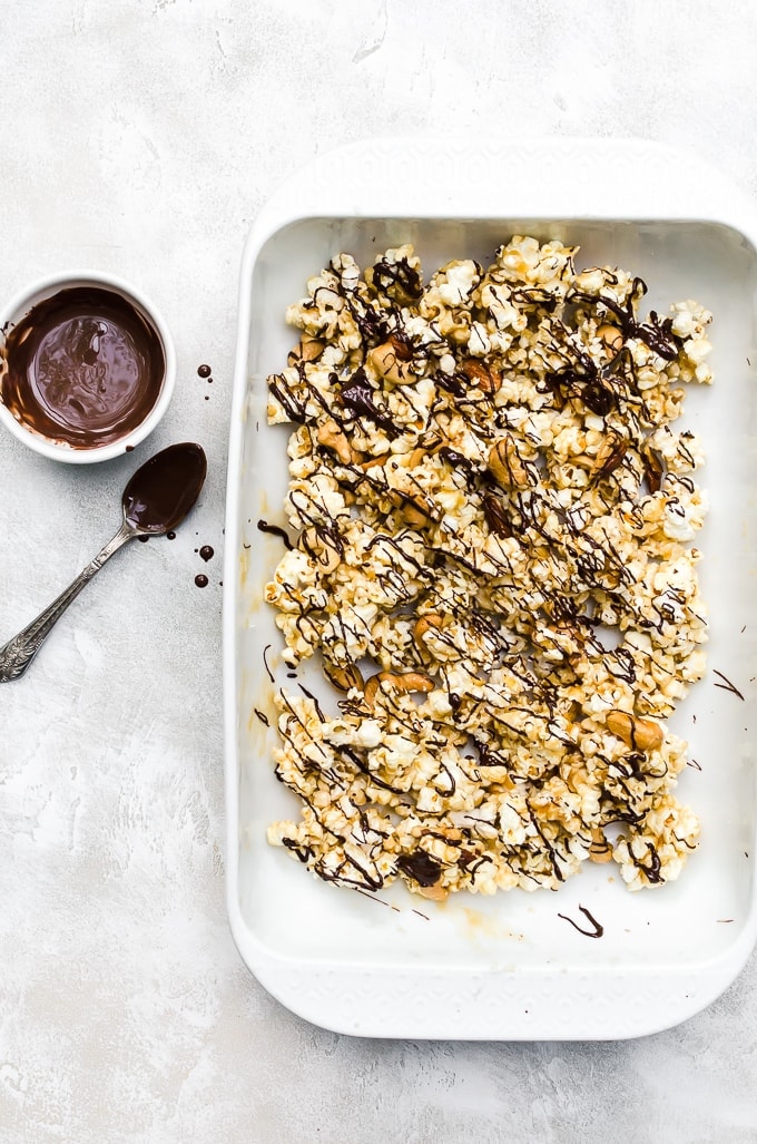 moose munch recipe in a white baking dish with drizzled chocolate