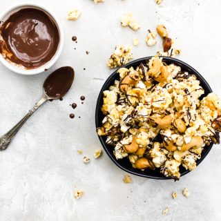 overhead shot moose munch recipe in a black bowl with drizzled chocolate