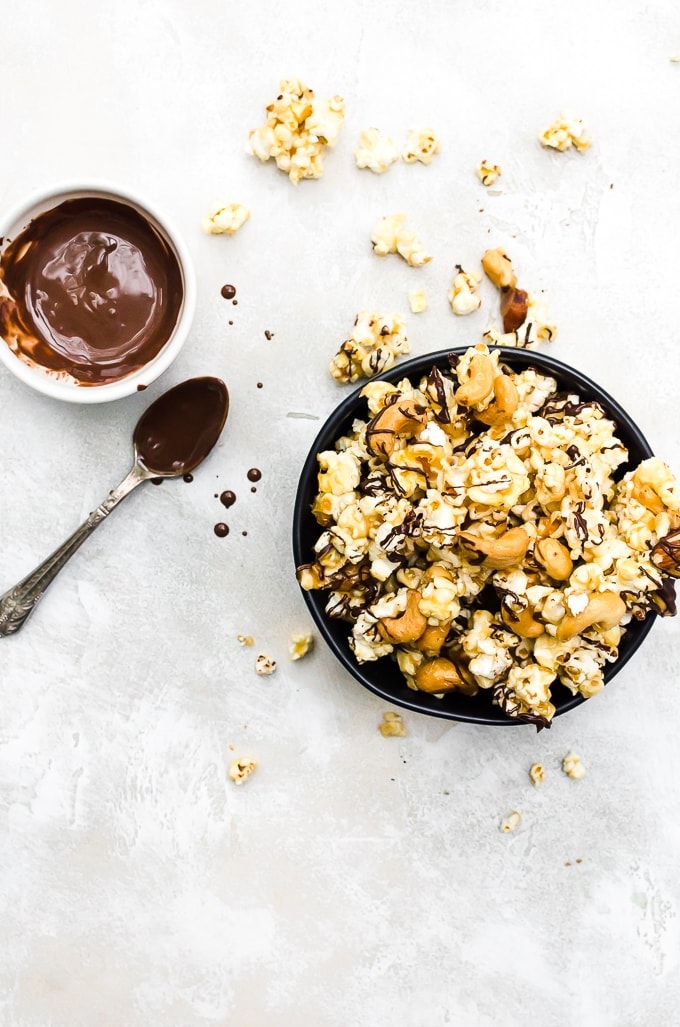 overhead shot moose munch recipe in a black bowl with drizzled chocolate