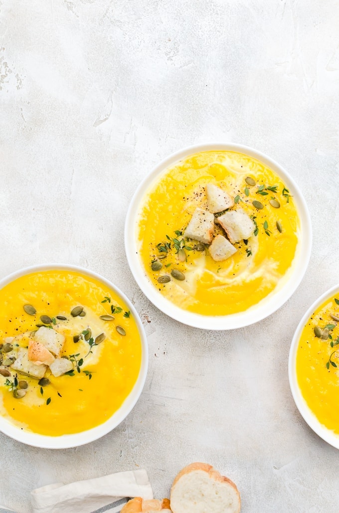 three bowls of roasted butternut squash soup in a row