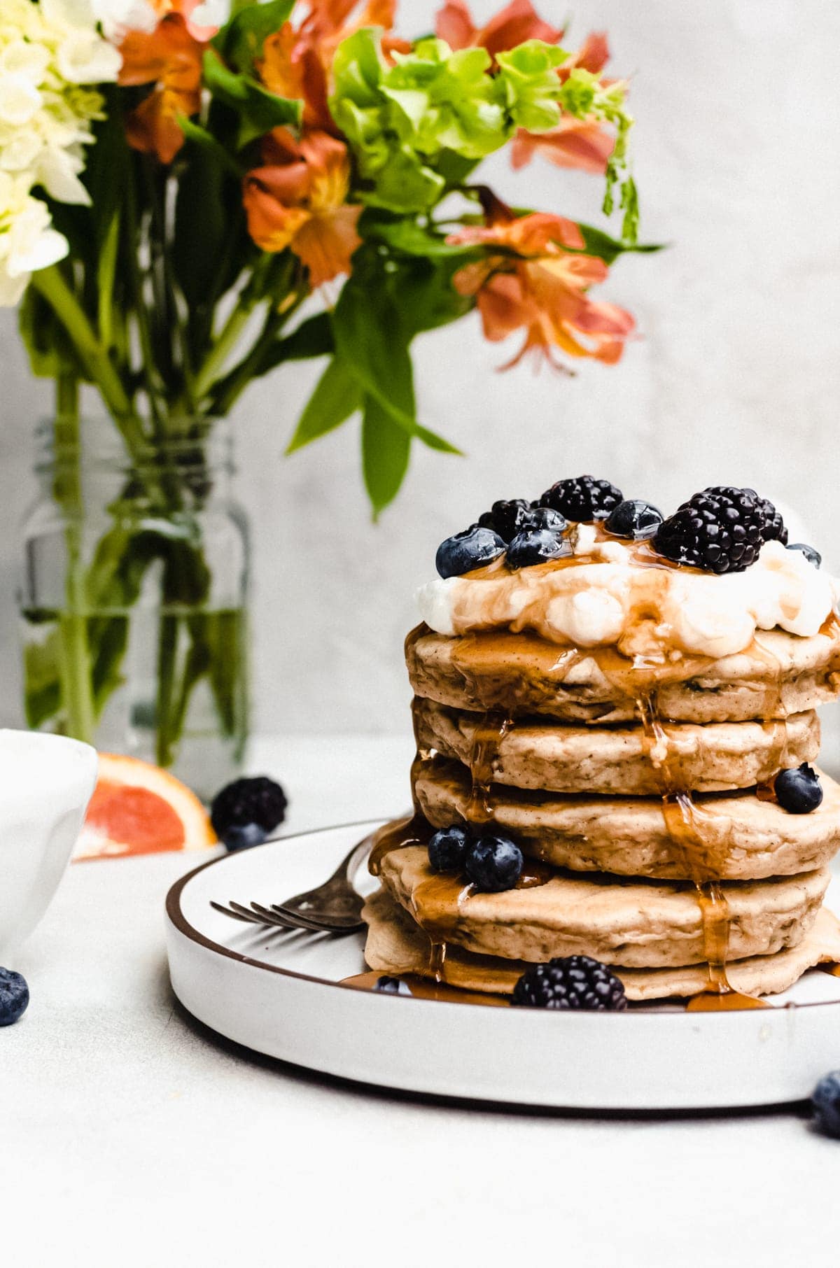 carrot cake pancakes smothered in whipped cream and maple syrup with berries