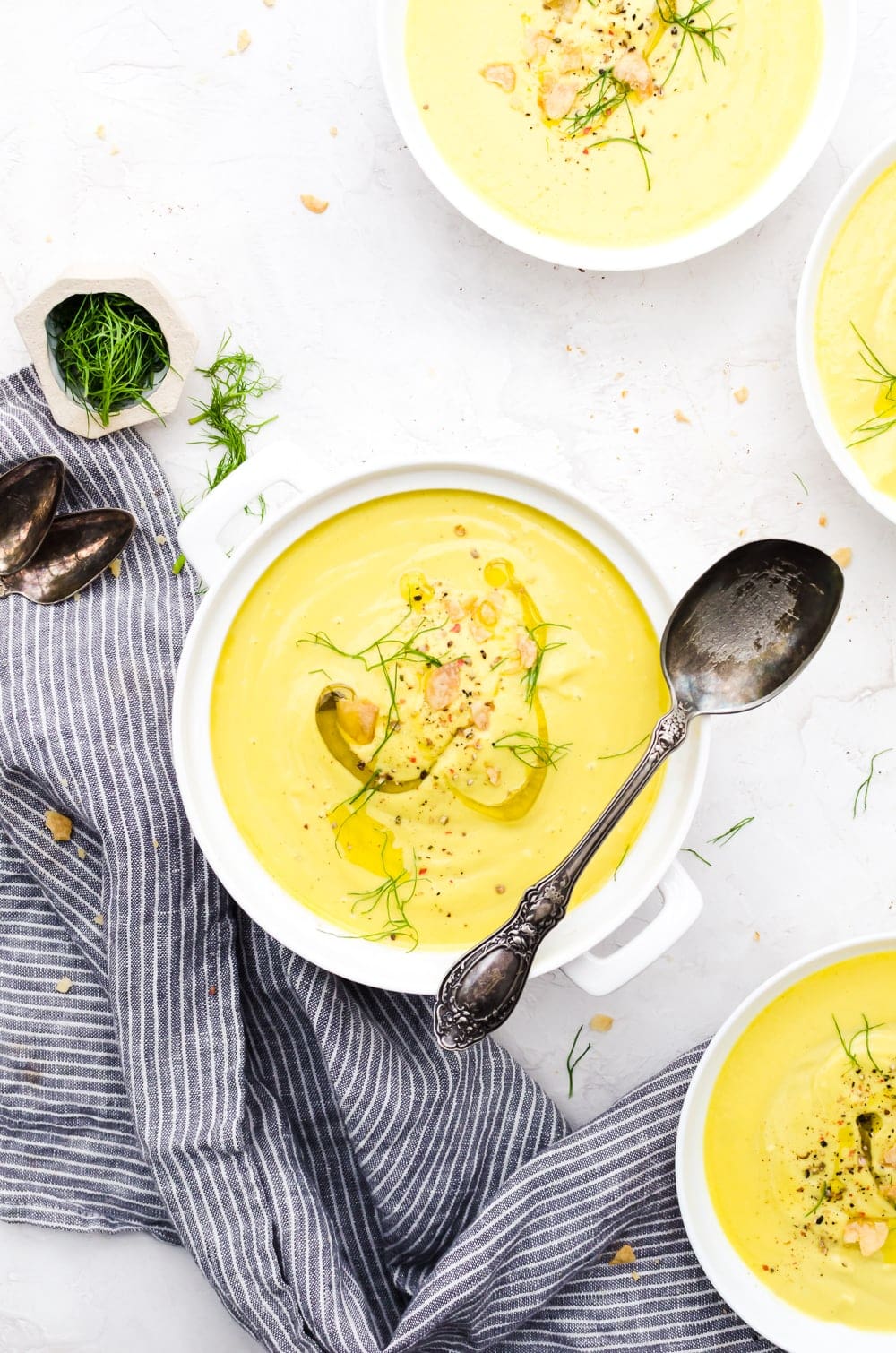 Overhead creamy cauliflower soup in container with spoon