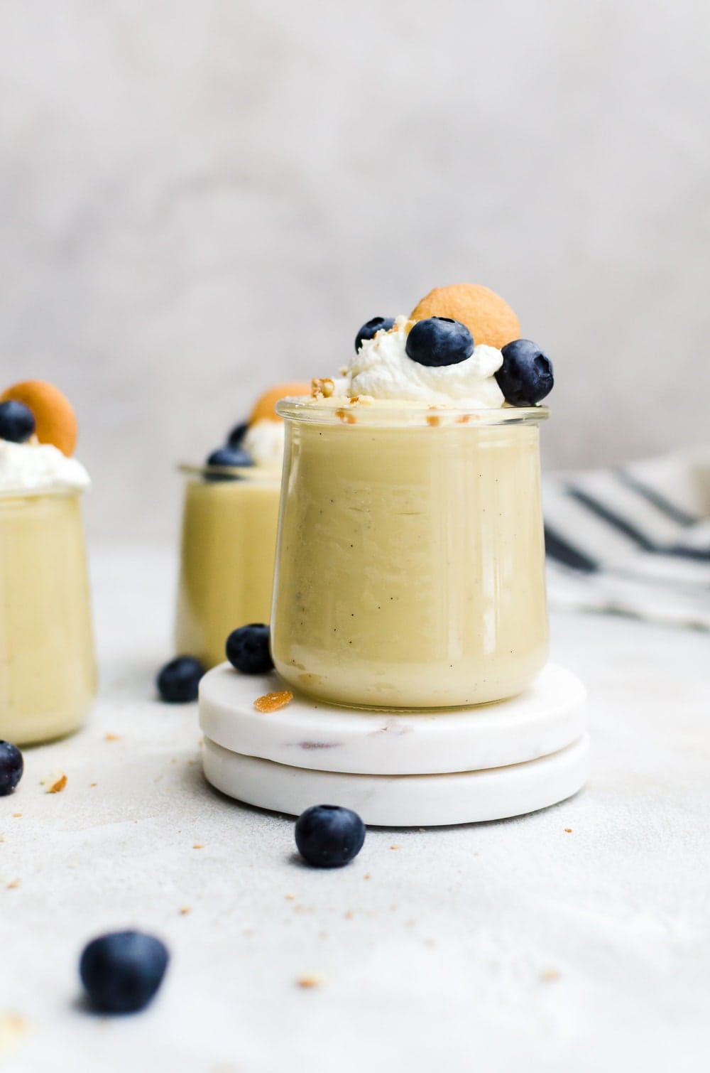 homemade vanilla pudding in glass jars with whipped cream