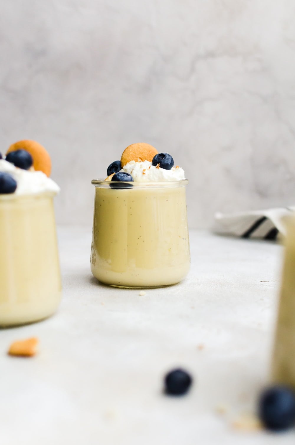 pudding in small cup topped with berries and whipped cream