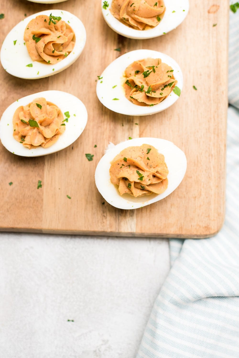 bbq deviled eggs on wood tray close up