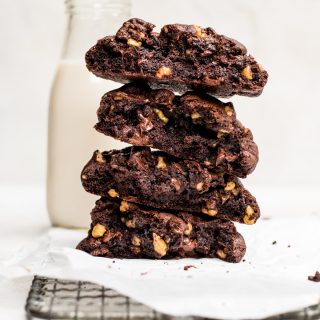 broken giant double chocolate cookies stacked with glass of milk
