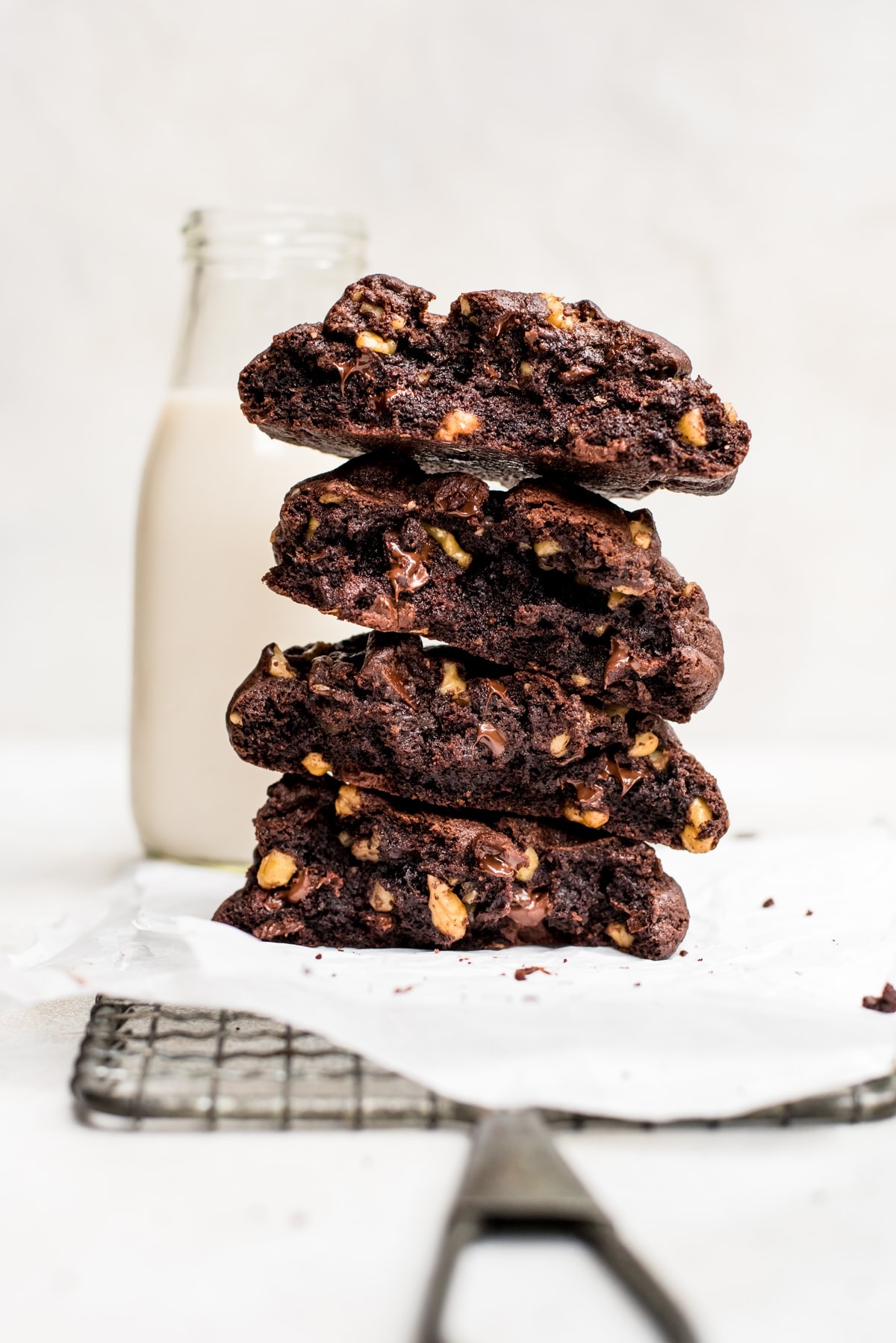 broken giant double chocolate cookies stacked with glass of milk