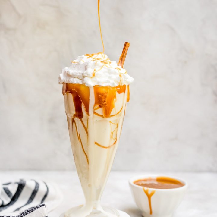 salted caramel milkshake drizzled with caramel in glass