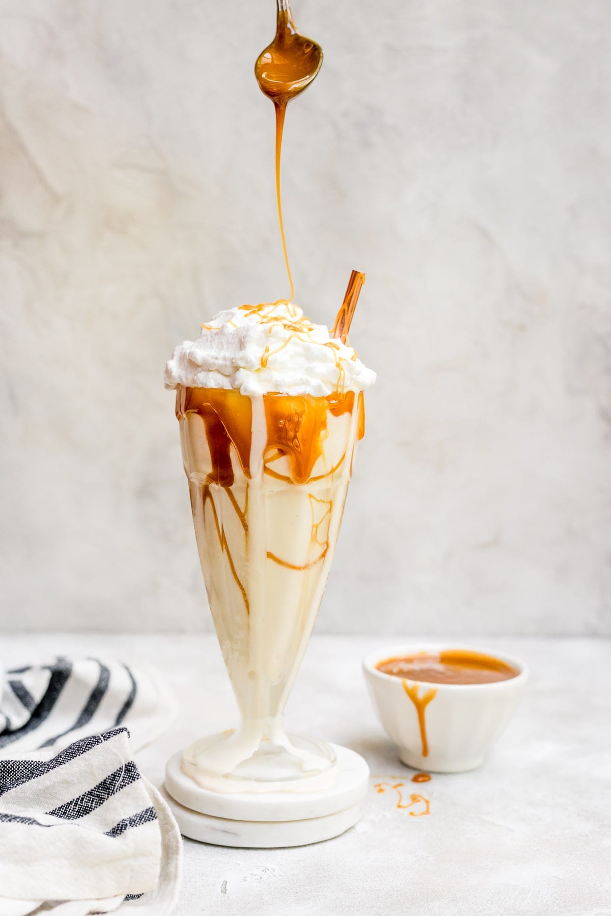 salted caramel milkshake drizzled with caramel in glass