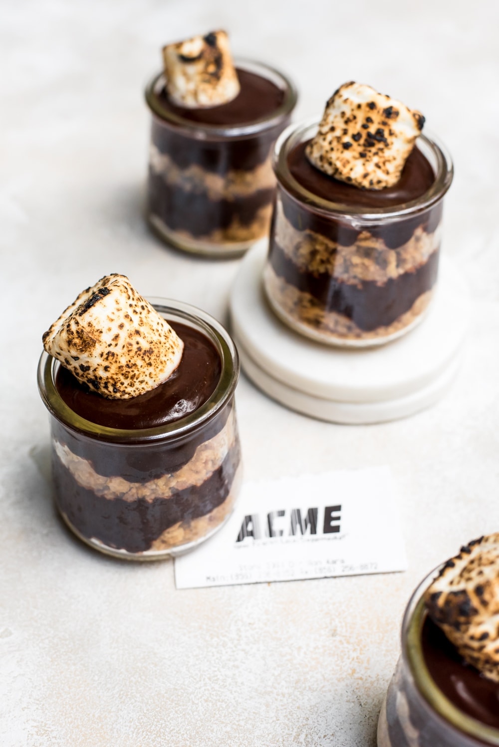 overhead s'mores pudding in jars on marble slabs