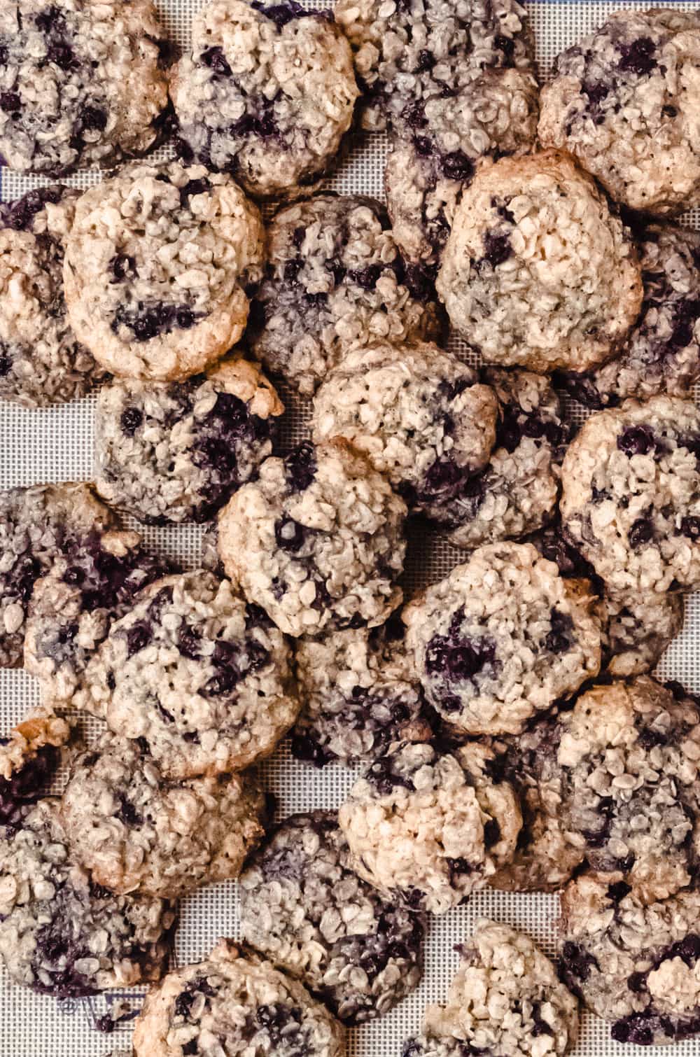 blueberry oatmeal cookies piled on baking sheet