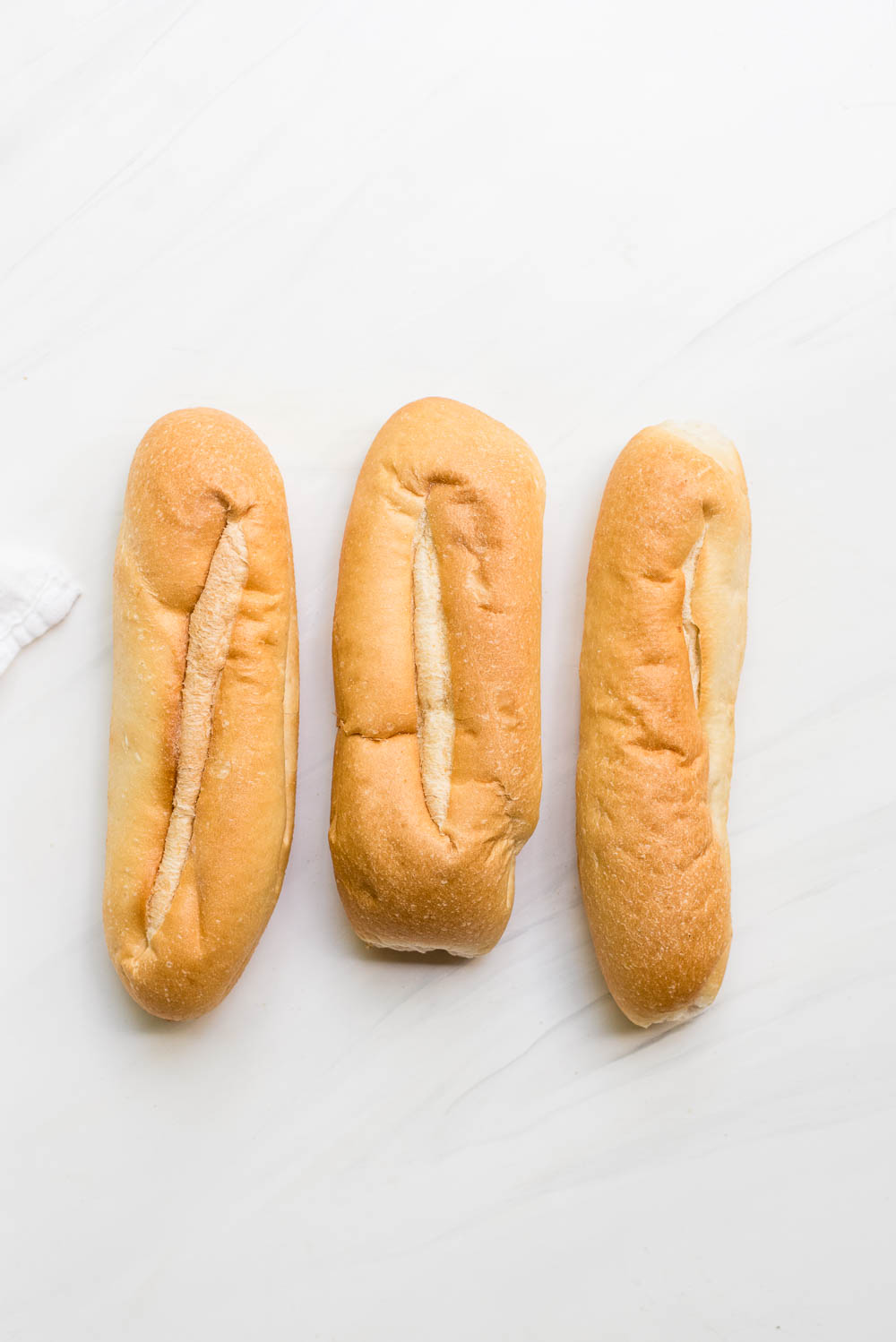 hoagie rolls lined up in a row overhead prep