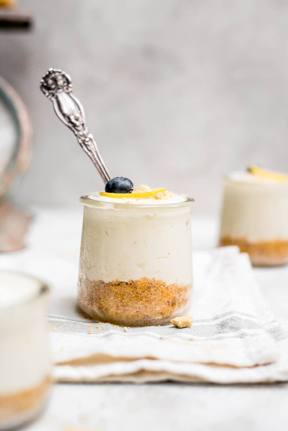 no bake lemon cheesecake in a jar on kitchen towel with spoon