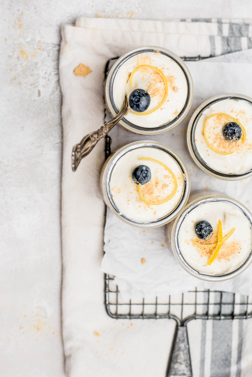 overhead no bake cheesecake in jars with lemon zest and blueberries