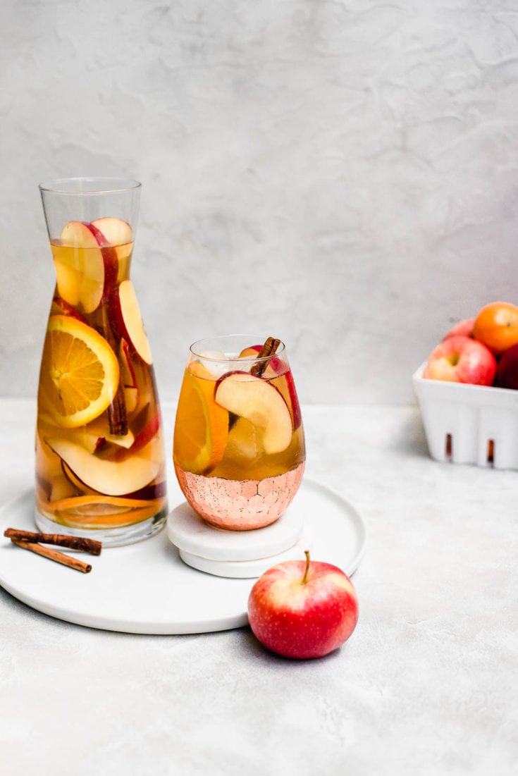 apple cider sangria on serving tray and coasters with apples