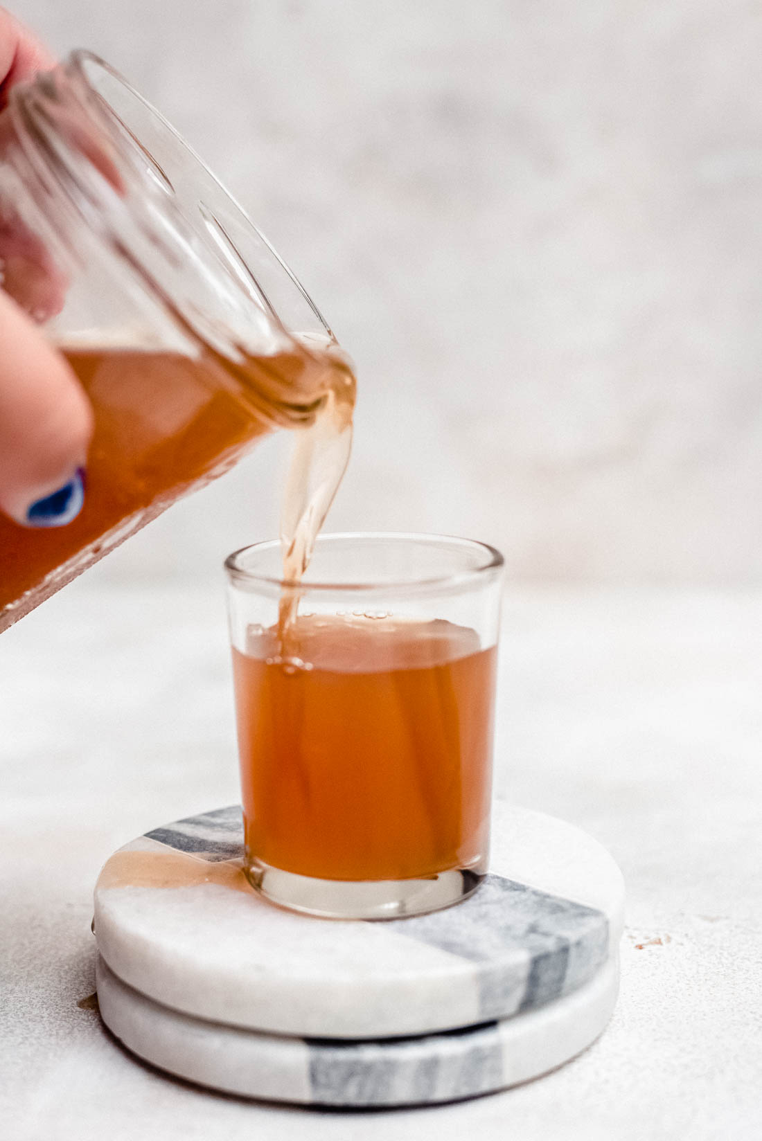 apple pie moonshine being poured in shot glass