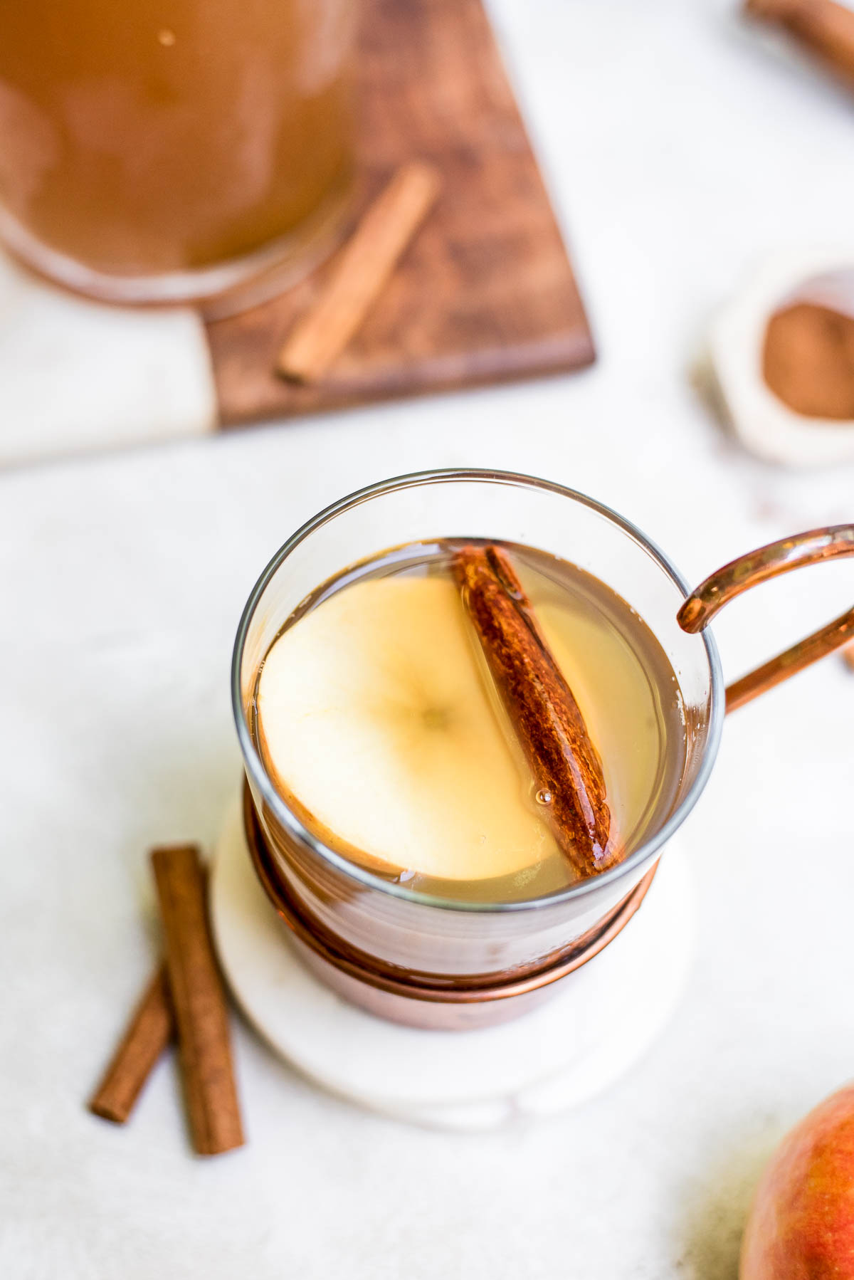 close up homemade apple cider in mug with garnishes